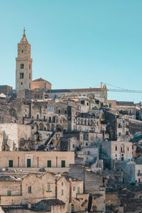 Buildings in city against clear blue sky