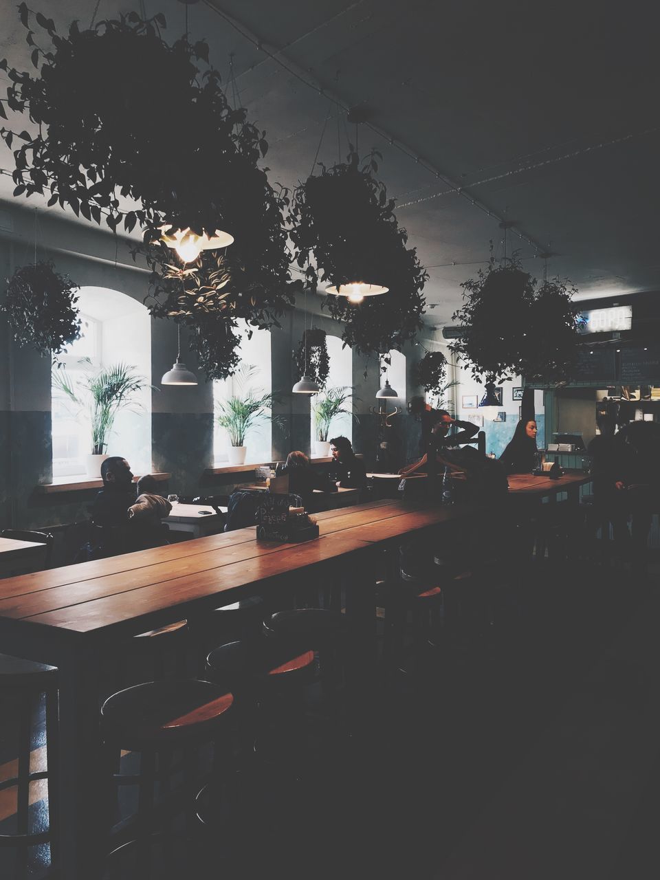 GROUP OF PEOPLE IN RESTAURANT AGAINST ILLUMINATED CITY