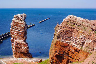 High angle view of rock formation in sea against sky