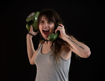 Portrait of woman wearing mask against black background