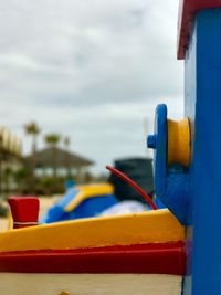 Close-up of boat moored at sea shore against sky