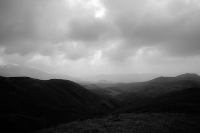 Scenic view of mountains against cloudy sky