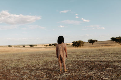 Rear view girl standing in the fields