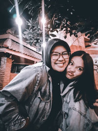 Portrait of smiling young woman at night