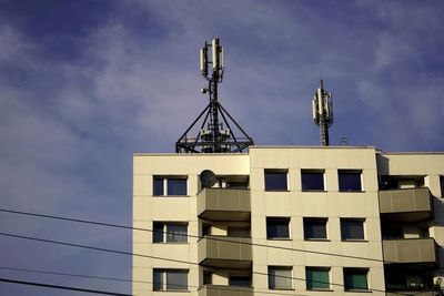 Low angle view of building against sky, mobile phone transmitter