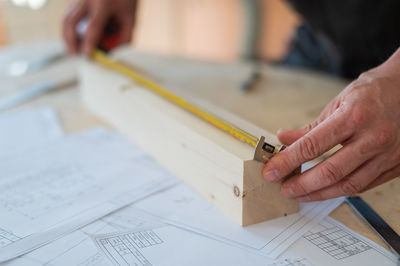 Midsection of man working on blueprint