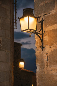 Low angle view of illuminated street light against building