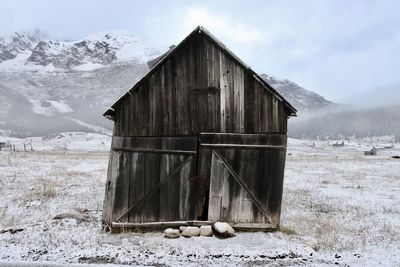 Abandoned house on field during winter