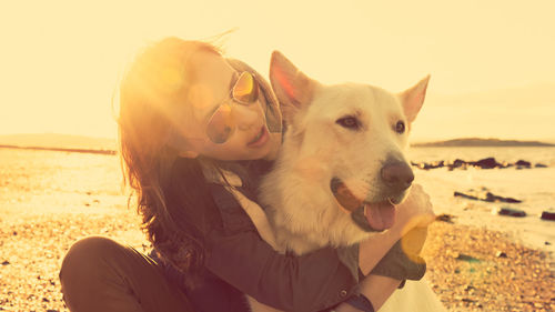 Woman playing with dog at beach