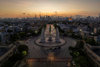 High angle view of illuminated city at sunset