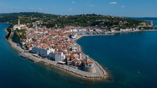 High angle view of townscape by sea against sky