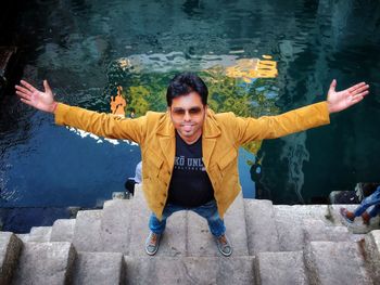 Portrait of young man with arms raised