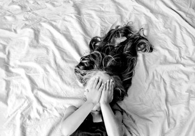 High angle view of girl lying on bed