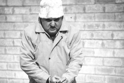 Mature man standing against wall