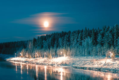 Scenic view of lake against sky at night during winter