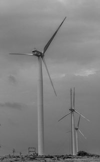 Wind turbines on land against sky