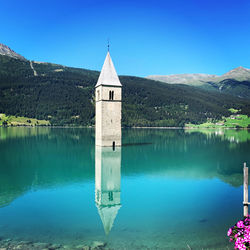 Building by lake against blue sky