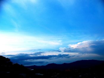 Silhouette of mountain range against cloudy sky