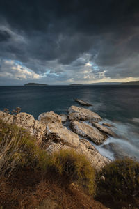 Rocks on sea shore against sky