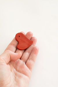 Cropped hand holding heart shape against white background