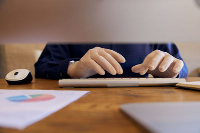 Close-up of hand holding smart phone on table