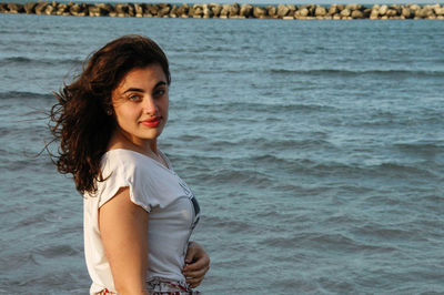 Portrait of young woman standing on beach