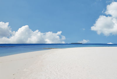 Scenic view of beach against blue sky