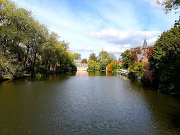 River amidst trees and buildings against sky