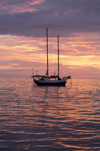 Boat sailing in sea at sunset
