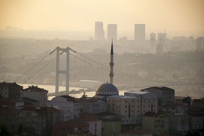 View of suspension bridge and buildings in city