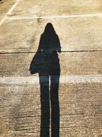 Shadow of woman standing on footpath