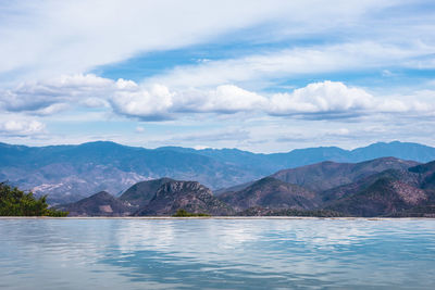 Scenic view of lake against cloudy sky