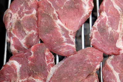 High angle view of meat steaks on barbeque grill