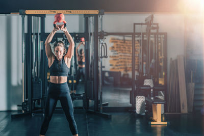 Woman swinging kettlebell in the gym.