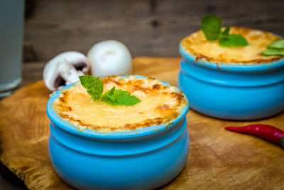 Pots with mushroom julienne on a wooden board.