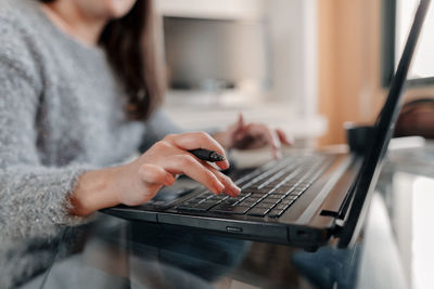 Midsection of woman using mobile phone at home