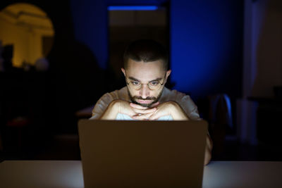 Thoughtful freelancer journalist or writer late at night work on laptop on project within deadline