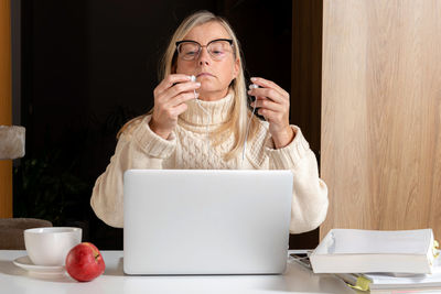 Midsection of woman with coffee cup on table