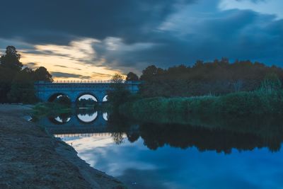 Arch bridge over river against sky