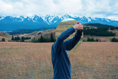 Man standing on field against mountains