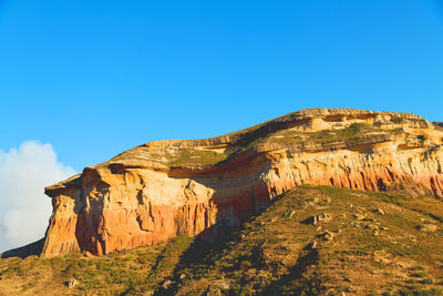 Rock formations on mountain against blue sky