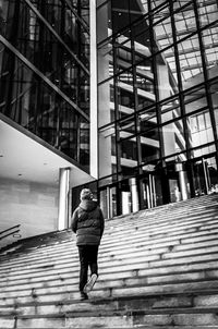 Rear view of woman walking on staircase in building