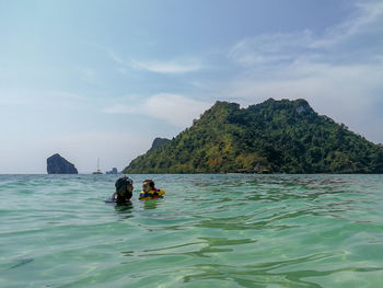 Man with baby girl in sea