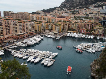 Yachts and boats are parked in monaco. mediterranean coast. mountains and tall buildings in the city