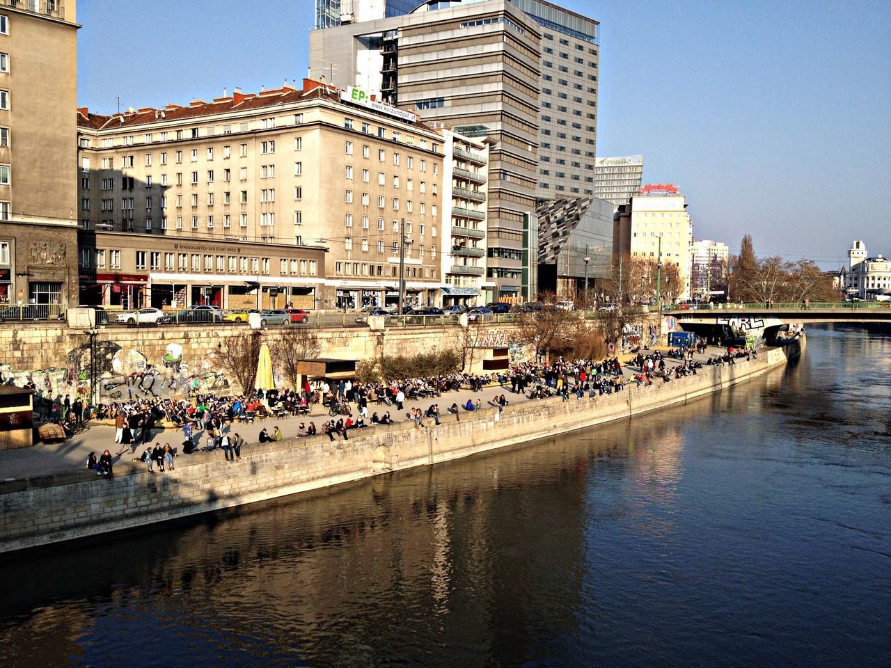 water, architecture, building exterior, built structure, waterfront, reflection, river, city, canal, clear sky, transportation, building, residential structure, day, residential building, incidental people, large group of people, outdoors, city life, lake