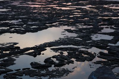 Reflection of sky on puddle in lake