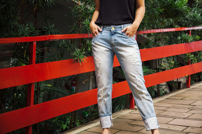 Low section of woman standing on footpath