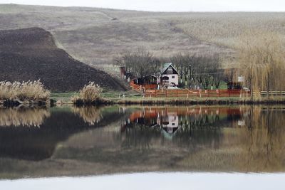 Scenic view of lake by buildings against mountain