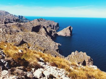 Scenic view of rocks in sea against blue sky