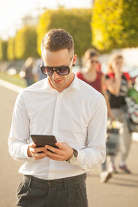 Young man using mobile phone in city